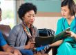 Healthcare professional reviewing documents with patients at a home health agency.