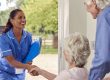 Caregiver greeting an elderly couple at home
